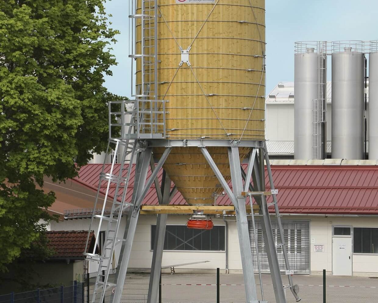 Streugutlagersilo in Holz-Stahl Bauweise vor einer Firmengebäude